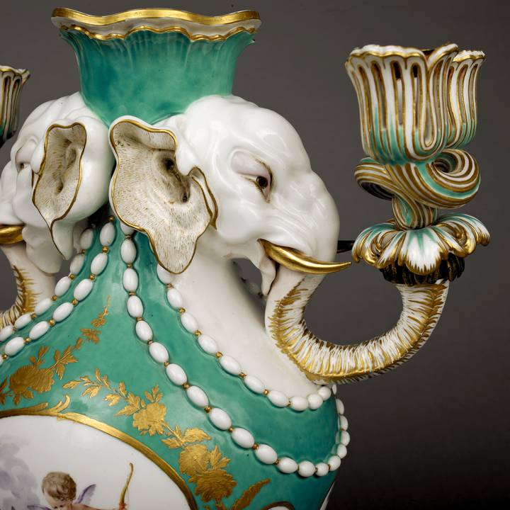 Side view detail of green and white vase with two elephant heads