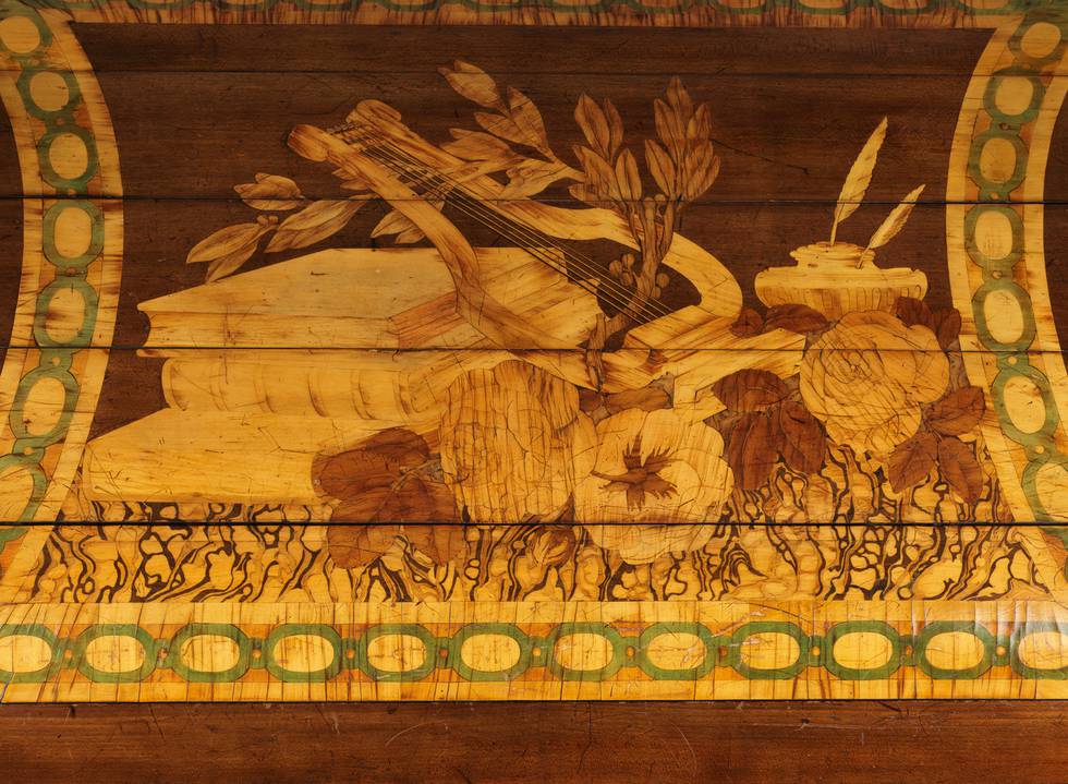 A detail of pictorial marquetry on the tambour of a roll-top desk