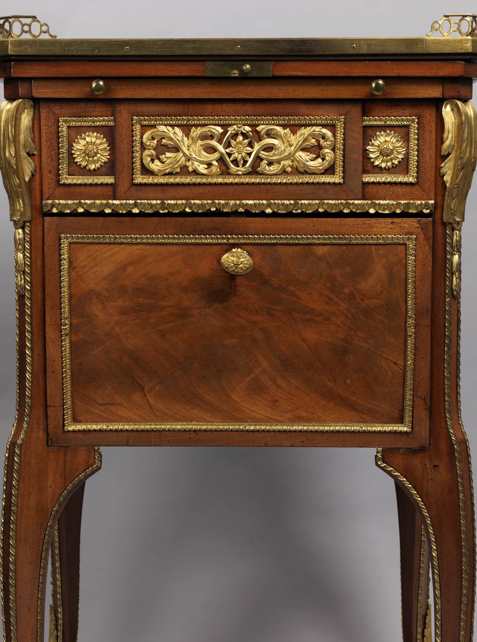 A detail of the front of a mahogany-veneered writing and toilet table