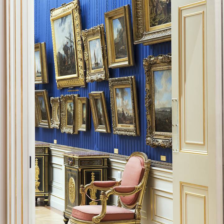 View through a door frame of paintings on gallery wall