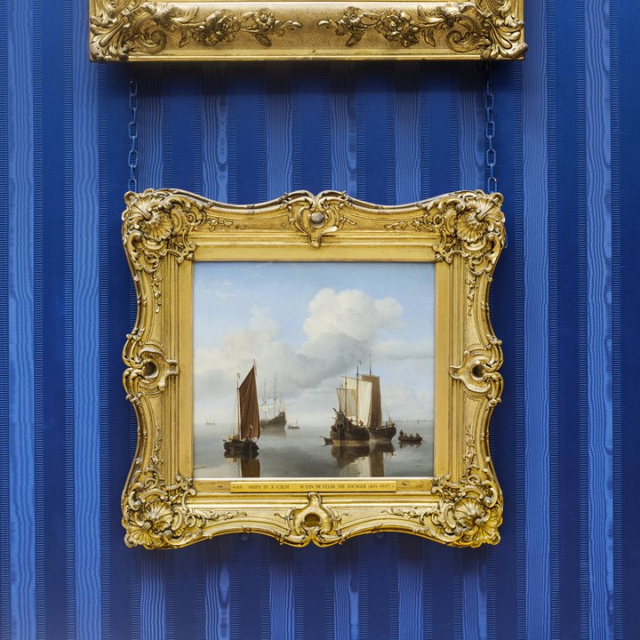 Seascape in gold frame on blue wall