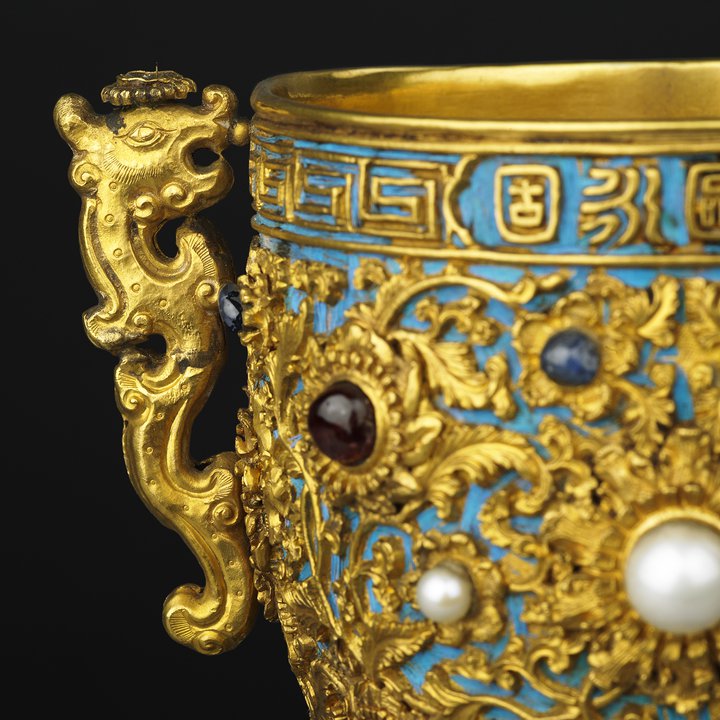 Detail of side of gold cup and dragon shaped handle